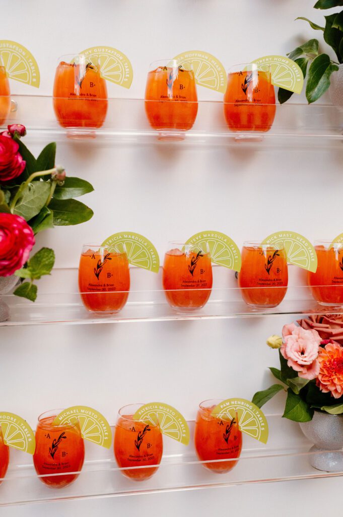 close up of customized drink glasses on wedding escort wall