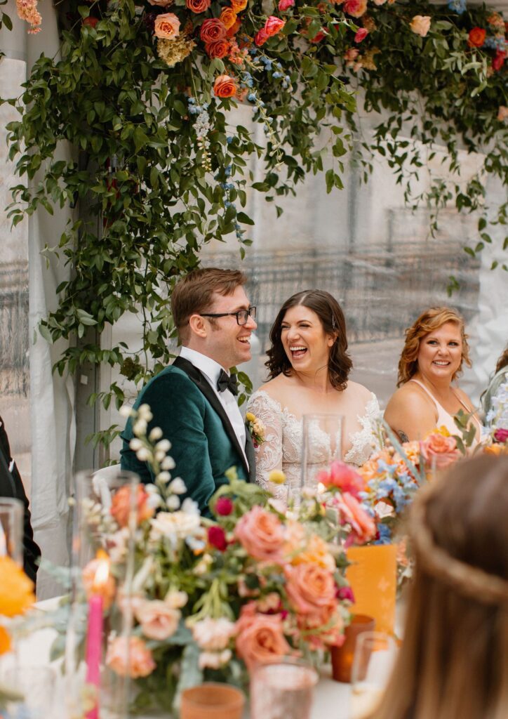 bride and groom laugh during wedding reception toasts